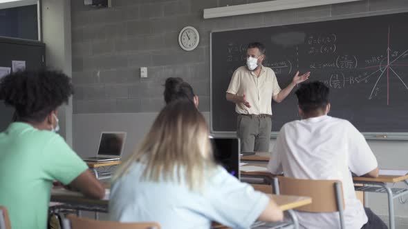 Maths Teacher and Students Wearing a Protective Face Mask in the Classroom