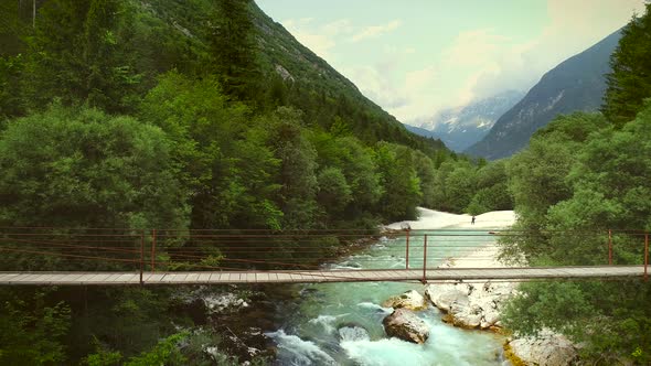 Aerial view of a man crossing a wooden bridge on a mountain bicycle.