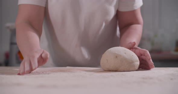 Female Hands Knead and Toss Dough on Kitchen