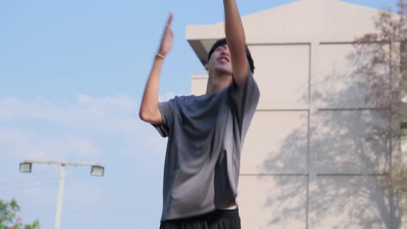 Young sports men practicing basketball on the outdoor court.