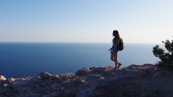 Girl Tourist Walks Along Mountain Looks to Sea