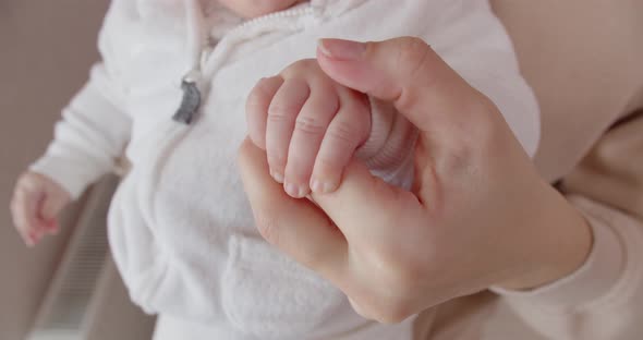 Mom Gently Strokes The Baby's Little Pen