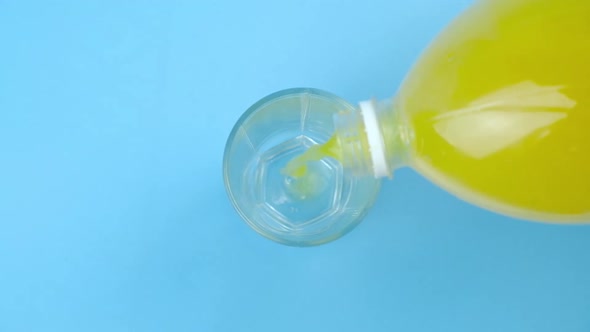 Orange Sweet Soda Water From a Bottle Pours Into a Glass