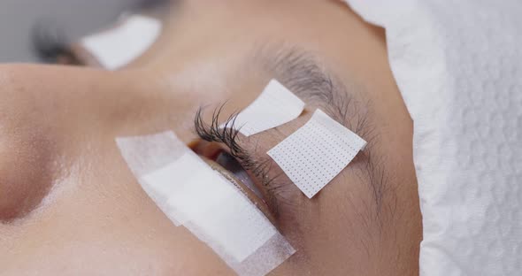 Female woman having eye lash extension in beauty salon