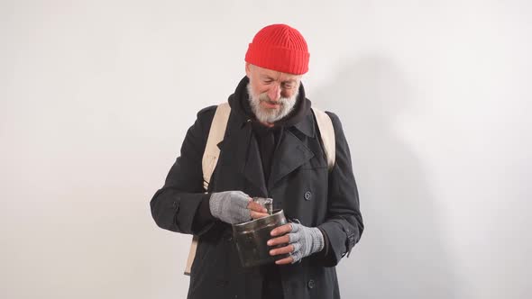 Portrait of Homeless Beggar with Cup for Money Finds Large Bill in His Cup