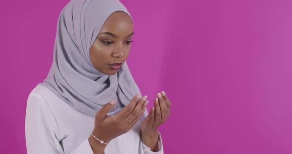 Modern African Muslim Woman Makes Traditional Prayer to God Over Colorfull Background