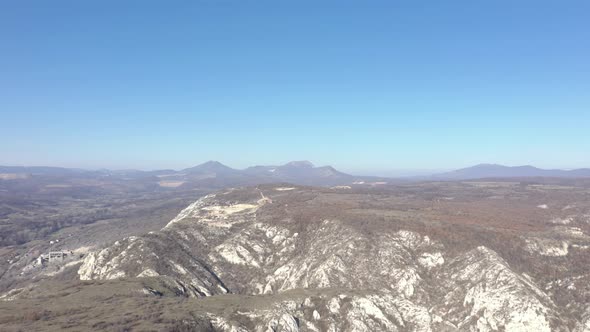 Descending on valley with Deli Jovan Krsh and Stol mountains in background 4K aerial video