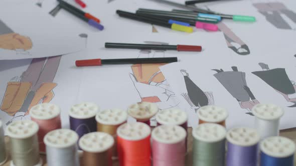 Close Up Of Clothes Drawing Pictures Are On The Table With A Sewing Machine In The Designer Studio