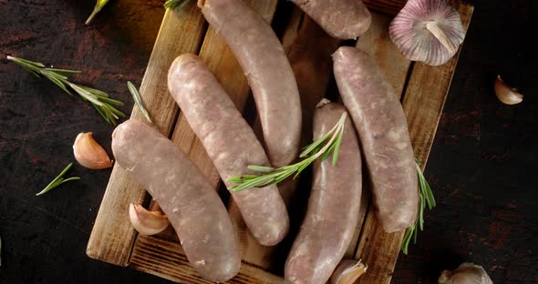 Raw Sausages with Sprigs of Rosemary Slowly Rotate. 