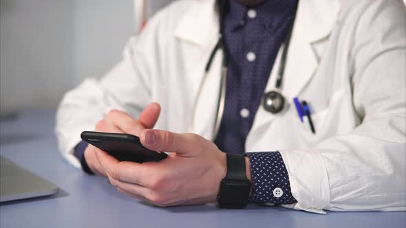 Close Up Shot of a Doctor's Hand, Who Uses the Smartphone To Find Medicines