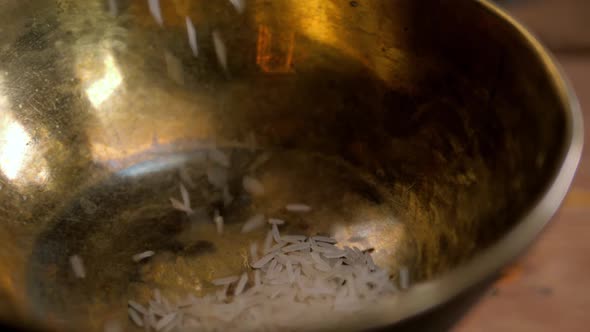 Dry Basmati Rice Fall in Wood Gold Metal Bowl on Table From Hands Woman Slow Motion Close Up Macro