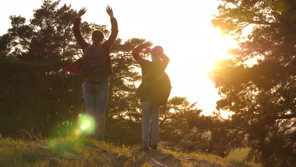 Two Girls Travel, Walk Through Forest and Wave Their Hands on Hill