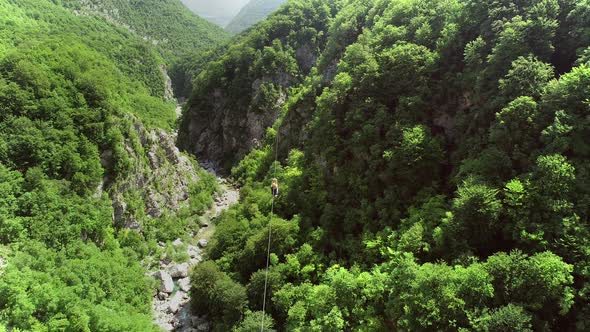 Aerial view of a person canopying over the forest in zip-line at Slovenia.