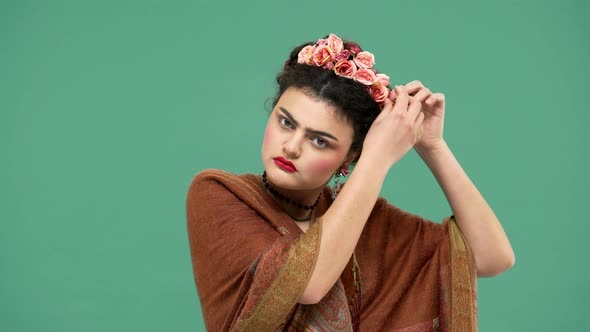 Fashion Portrait of Woman Wearing Traditional Necklace Putting Beautiful Flowers Roses in Hair