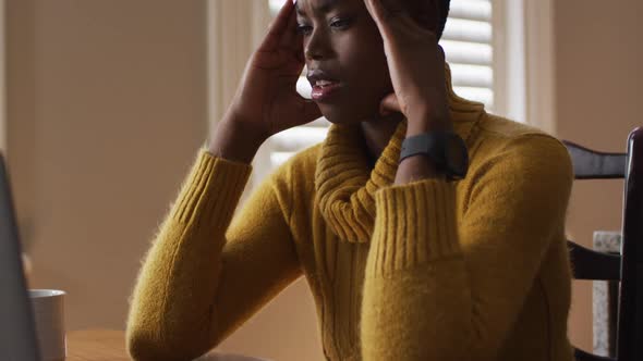 Stressed african american woman using laptop while working from home