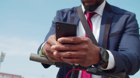 Man Using Smartphone to Rent Escooter to Commute