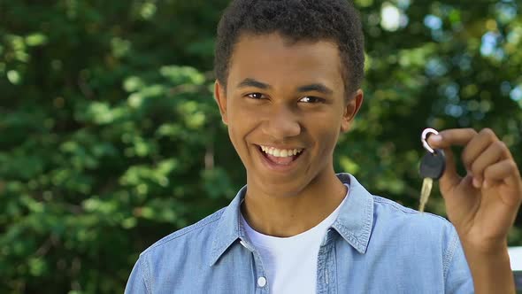 Happy Black Teenage Boy Showing Auto Keys to Camera, Getting Driver License