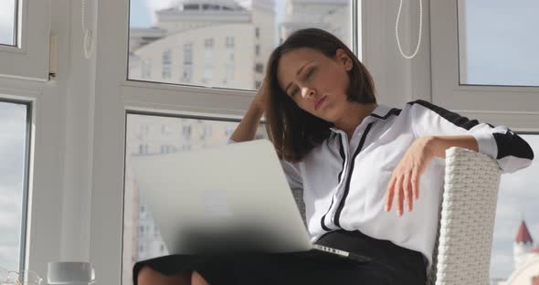 Concentrated upset female office manager sitting in modern office and looking at computer monitor