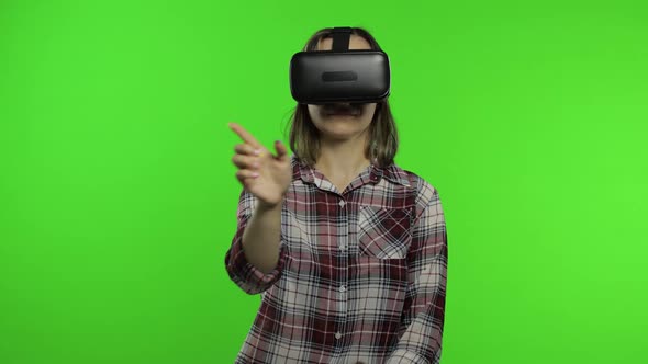 Girl Using VR App Helmet To Play Simulation Game. Slide Gestures. Watching Virtual Reality 3d Video