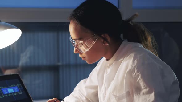 Close Up of African American Engineer in Protective Glasses Working in Electronics Lab