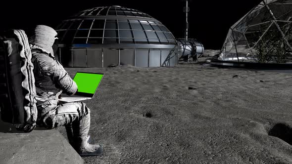 Astronaut on the Moon Typing on a Laptop with a Green Screen