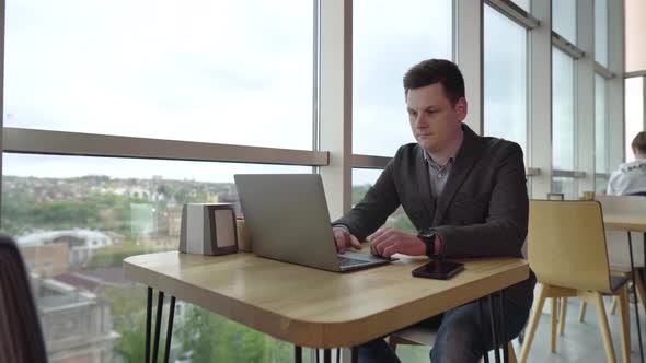 Freelancer Working on Laptop in the Coworking