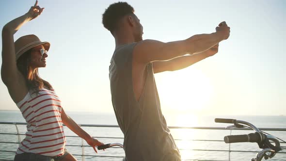 Portrait of a Mixed Race Couple Doing Selfie on Tandem Bicycle Outdoors Near the Sea Slow Motion