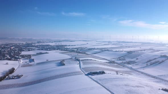 Snowy Fields And Community Near Wind Farm At Winter In Zistersdorf, Lower Austria. - aerial