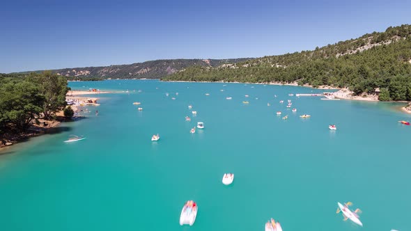 Beautiful view of boats floating around in a lake in france with clear turquoise water