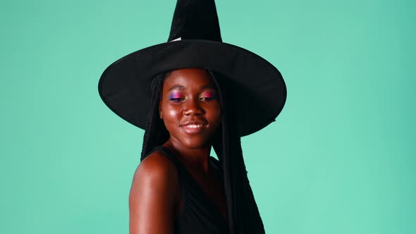 Young Beautiful Woman Wearing Witch Halloween Costume Smiling Cheerful in Blue Background in Studio