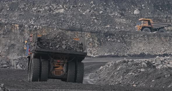 Slow Motion Shooting Big Trucks on Coal Mining and Breed Transportation. Huge Heavy Dump Truck Is