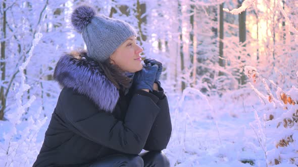 Winter Portrait of Young Attractive Woman in Snowy Forest