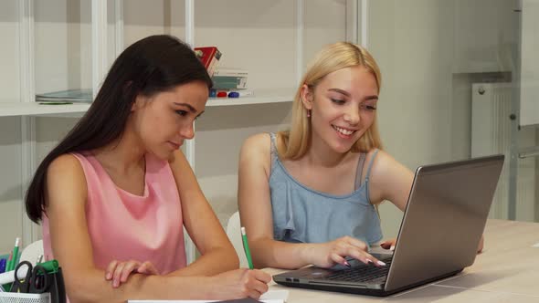 Two Beautiful Female Students Studying Using Laptop Together