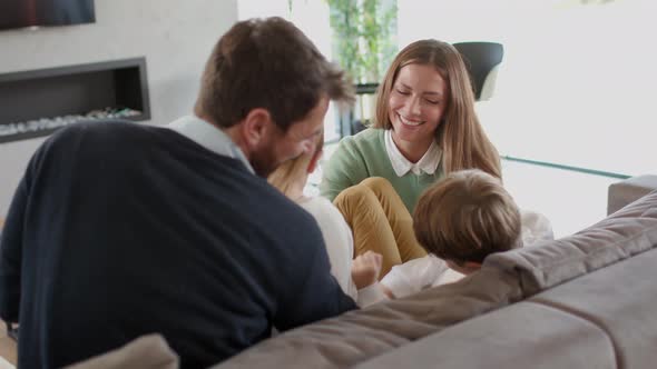 Happy family with two kids enjoy time together on couch in living room