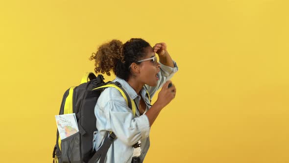 Portrait of a smiling young African American woman backpacker take photos