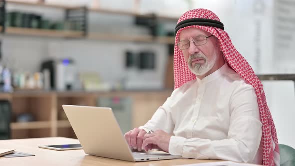 Senior Old Arab Businessman with Laptop Looking at Camera