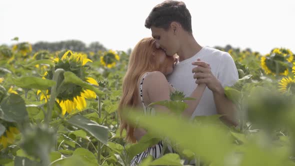 Beautiful Happy Couple Dancing Together on the Sunflower Field, the Woman Spinning Around