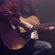 A male guitarist plays an acoustic guitar in a dark room. - VideoHive Item for Sale
