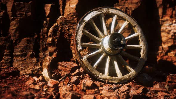 Old Wooden Cart Wheel on Stone Rocks