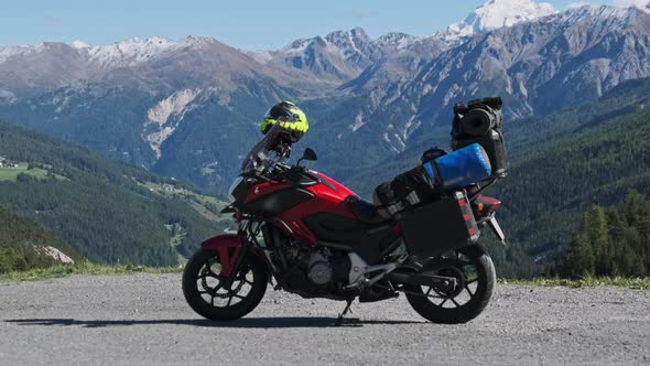 Motorbike with Motorcycle Cases Stands Against Mountain Landscape of Swiss Alps