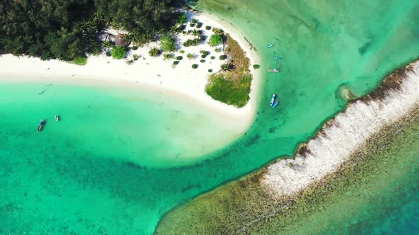 Aerial top view scenery of tranquil coastline beach trip by blue ocean and white sandy background of