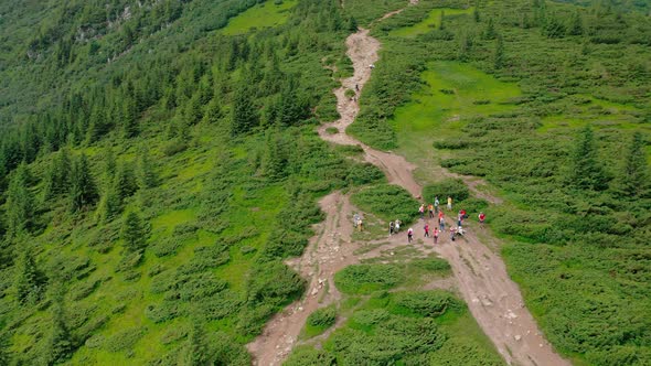 Aerial View of a Group of Young Tourists Stopped to Rest Before Climbing the Mountain Peak