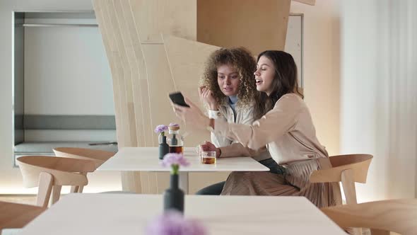 Pair of Young Women Making Selfie in Restaurant