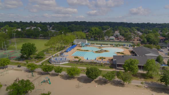 Aerial Pan from Outdoor Pool to a Childrens Sandy Playground