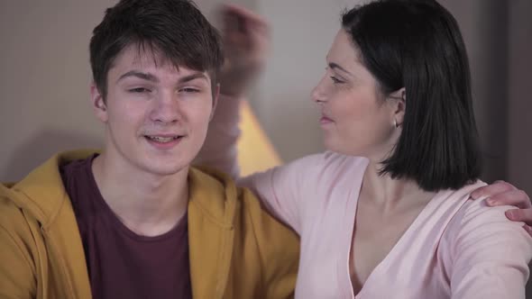 Portrait of Young Positive Caucasian Woman and Teenage Boy Looking at Camera and Smiling. Happy