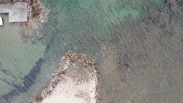 Aerial footage of the ocean and small harbour of the village of George South in the city of Corfu 