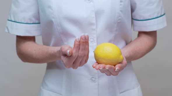 Nutritionist Doctor Healthy Lifestyle Concept - Holding Lemon Fruit and Medicine or Vitamin Pill