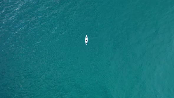 A Girl Swims on a Board in the Open Sea Filmed on a Drone