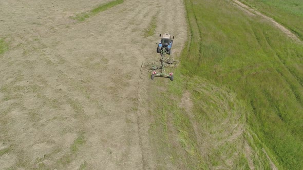 Tractor with Rake Tedders on the Farm Field