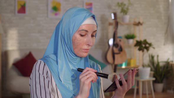 Muslim Woman in a Hijab with a Burn Scar on Her Face Doing Makeup